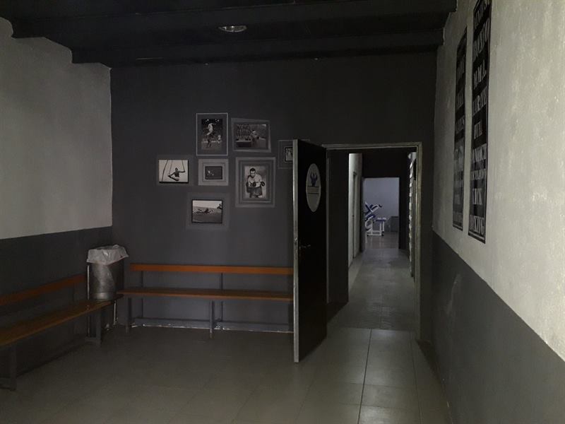 Vestíbulo interior del gimnasio con bancos y acceso a las salas